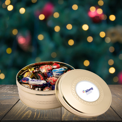 Branded gold tin of Celebrations chocolates with a Christmas background