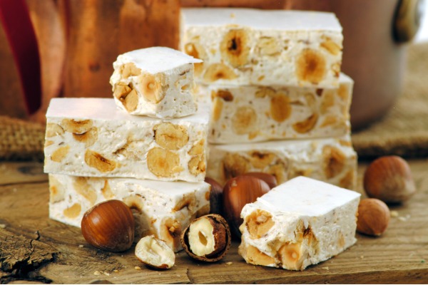 Italian Christmas torrone nougat bar with almonds, sliced to show its smooth, creamy texture.