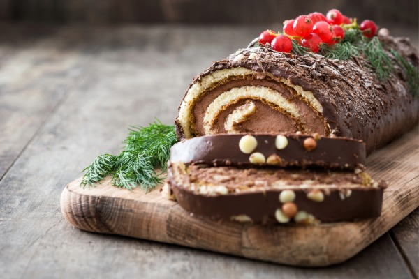 Classic French Bûche de Noël Christmas cake decorated with chocolate frosting and festive toppings.