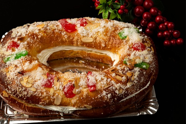 Spanish Roscón de Reyes ring-shaped cake decorated with candied fruits and a icing sugar
