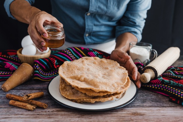 Crisp Mexican buñuelos dusted with cinnamon sugar, served as a festive Christmas and New Year treat.