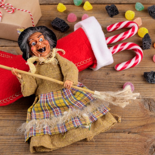 La Befana, the Italian gift-bringer, flying on her broomstick with gifts.