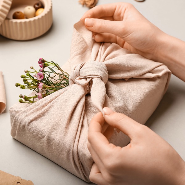 Gift wrapped using the Japanese furoshiki technique, with fabric neatly tied into a decorative knot.