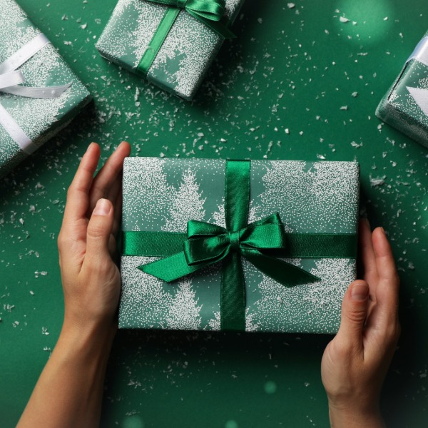 Green gifts wrapped with matching green ribbons, arranged for a festive display.