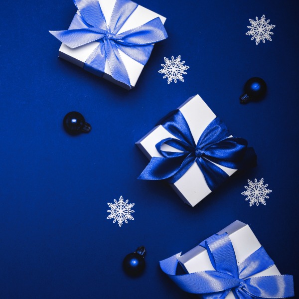 White gifts adorned with blue silk ribbons, elegantly arranged for a festive display.